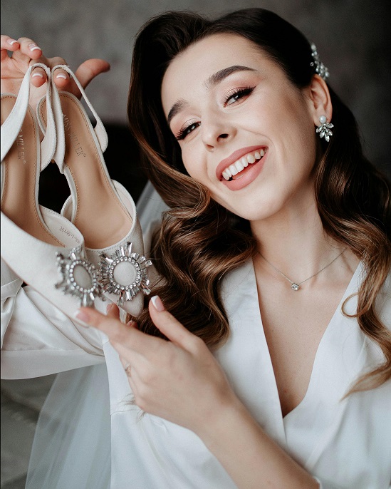mulher roupa branca segurando scarpin branco